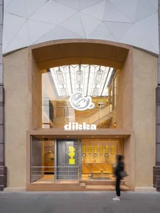 A bright and welcoming office space with a large window allowing sunlight to enter, featuring two people in the scene