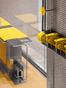 A well-lit interior space with a yellow bench and a window, creating a comfortable atmosphere