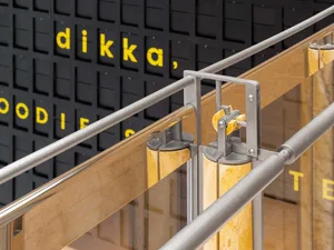 A modern staircase with metal railings on both sides, set against a neutral background