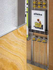 A modern cafe interior with a marble countertop, yellow wall, and two sinks, a refrigerator, and a clean and functional atmosphere