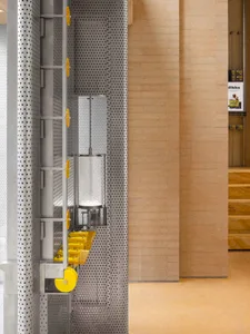 Wooden room with a metal panel featuring yellow dots and a mounted mirror adding depth and interest