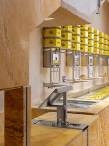 An inviting ice cream shop with a marble counter displaying various flavors of ice cream in cups, surrounded by a warm and enticing atmosphere