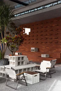 Cozy room with a brick wall, a large tree, two chairs, and a dining table