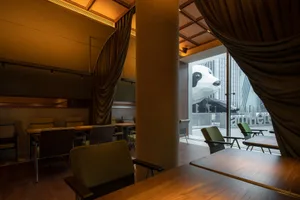 A well-lit dining area with multiple tables and chairs, inviting atmosphere, and natural light from windows