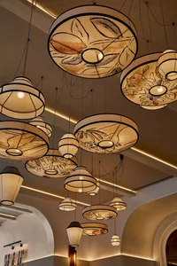 A warm and inviting room with various hanging lamps and lanterns suspended from the ceiling, creating a cozy ambiance