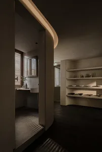 Dimly lit bathroom with tile walls, a sink, a mirror, and decorative vases