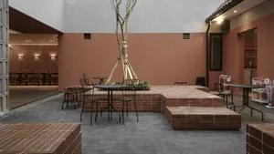 A wooden dining table surrounded by chairs in a cozy outdoor patio with a potted plant and inviting atmosphere