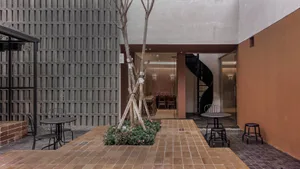 A cozy outdoor patio with a dining table surrounded by chairs and potted plants, perfect for socializing and enjoying meals outside