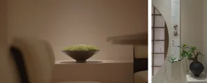 A black ceramic bowl filled with green substance sits on a wooden table in a simple setting