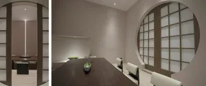 A dimly lit room with a wooden dining table and four chairs, two vases, and a cozy atmosphere