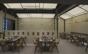 An empty restaurant with numerous dining tables and chairs, creating a comfortable and inviting atmosphere with a focus on functionality