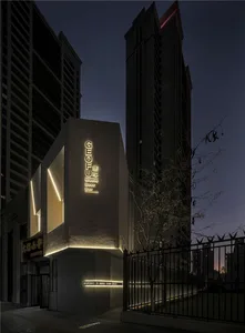 A modern building with a concrete structure and a prominent sign, set against a dark night sky