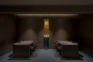 正式餐廳區域，設有兩張餐桌與椅子、木質地板及裝飾花瓶，位於光線充足、溫馨舒適的房間內