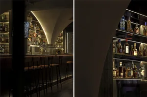 A well-stocked bar with bottles and chairs arranged around the counter, creating a cozy atmosphere for socializing and enjoying drinks