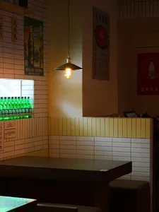 A casual bar area with a yellow tile wall, a counter with beer bottles, and a welcoming atmosphere