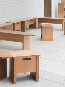 A room with multiple wooden tables arranged for comfortable seating and workstations, creating a sense of organization and functionality