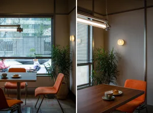 A restaurant or living area with chairs and a couch, surrounded by potted plants, creating a welcoming atmosphere for visitors