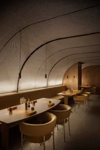 Warm and inviting restaurant interior with dining tables, chairs, and potted plants