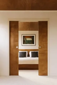 A cozy bedroom with a large bed, mirrored closet, and decorative artwork above the bed