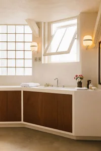 Modern bathroom with two sinks, a large mirror, and a window above the sink area