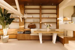 A warm and inviting living area with wooden floors and walls, featuring bookshelves, a dining table, and comfortable seating