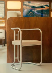 A cozy dining space with a wooden table and a metal-framed chair, accompanied by two additional chairs, creating a warm and inviting atmosphere