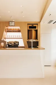 Warm and inviting restaurant kitchen with wooden walls and floors, featuring two sinks, bottles, and a clock, creating a cozy atmosphere