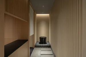 Small bathroom with a black toilet, two sinks, and wood paneling on the walls