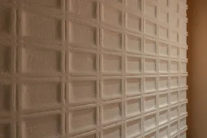 A minimalist white wall with a repeating pattern of squares, creating a clean and elegant interior design element