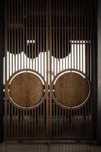 Elegant interior space with wooden doors featuring intricate carvings, open to reveal a view of another room