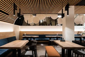 Warm and inviting restaurant interior with wooden tables and chairs, well-lit for a comfortable dining experience