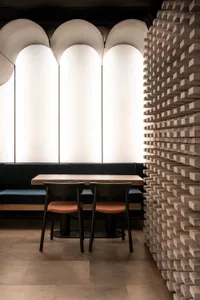 Spacious restaurant interior with two dining tables, white walls, and modern chairs