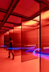 A bright and inviting hallway with red walls and doors, featuring two people in a well-lit space