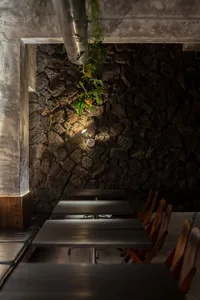A restaurant dining area with multiple wooden tables and chairs arranged in rows, creating a comfortable seating arrangement for guests