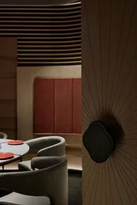 Cozy dining space with wooden walls and floors, dimly lit with chairs and tables for guests