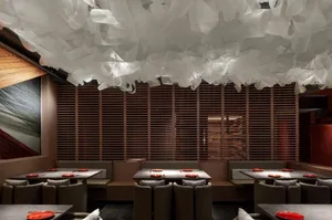 Warm and inviting restaurant interior with wooden tables and chairs, dimly lit for an intimate ambiance