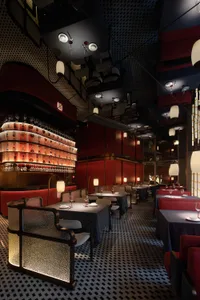 Elegant dining area with wooden tables, chairs, and wine glasses, set in a comfortable and inviting atmosphere