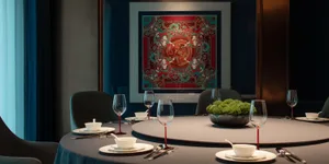 Elegant dining area with a round table set for dinner, featuring wine glasses, cups, and utensils, surrounded by four chairs