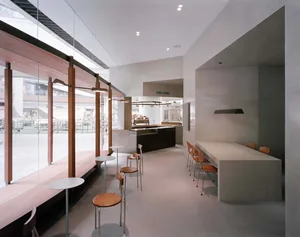 An open concept restaurant with a modern design, featuring a large dining area with tables and chairs, creating an inviting and comfortable atmosphere