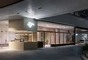 Open modern restaurant with natural light, white walls, wooden floors, and seating areas