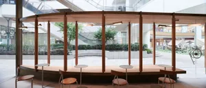 Bright studio space with a glass wall, chairs, and natural light