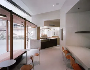 A bright and inviting kitchen with a countertop, sink, and dining table, surrounded by three chairs