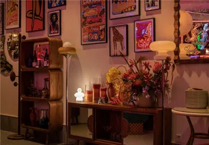 Cozy interior space with a wooden table, vases, a chair, and a potted plant, featuring a focus on artistic expression through object arrangement