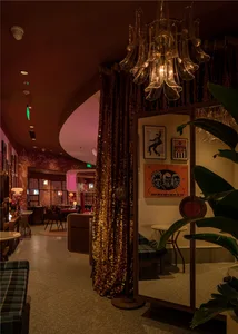 Cozy cafe dining area with tables, chairs, couches, and potted plants