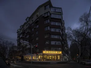 A city restaurant with a brick exterior, multiple floors, and numerous windows, offering a welcoming atmosphere with ample natural light