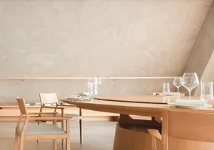 Empty restaurant dining area with a large wooden table and multiple chairs, clean and organized space ready for guests