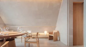 An inviting dining space with a table and chairs, a couch, and wine glasses, set for a meal or gathering
