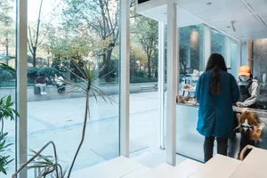 A casual indoor cafe with a variety of seating options, multiple counters, and people enjoying their time