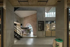 Open modern space with a concrete floor, a staircase, and large windows providing natural light