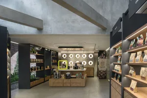 現代商店內部，乾淨線條、極簡裝飾，窗戶帶來自然光線，展示架陳列各種家居用品